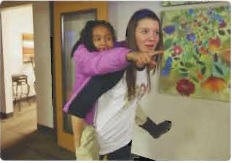 PLU student carrying a young person on her back