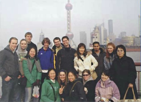 Students posing in front of another country's cityscape