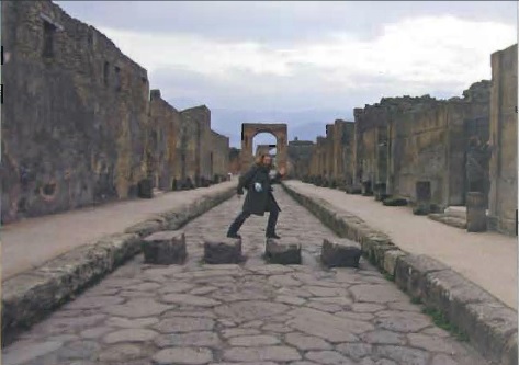 Student walking across stones of a dry man made river