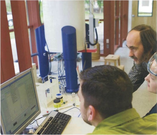 Professor and students working with the nuclear magnetic resonance spectrometer
