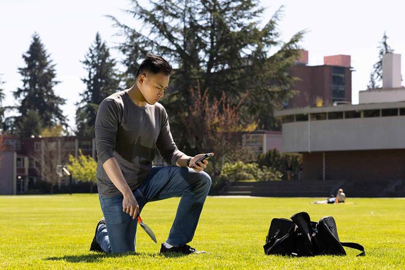 Vincent collects soil samples on PLU’s campus for his capstone project comparing radiation levels here to levels near Mount St. Helens.