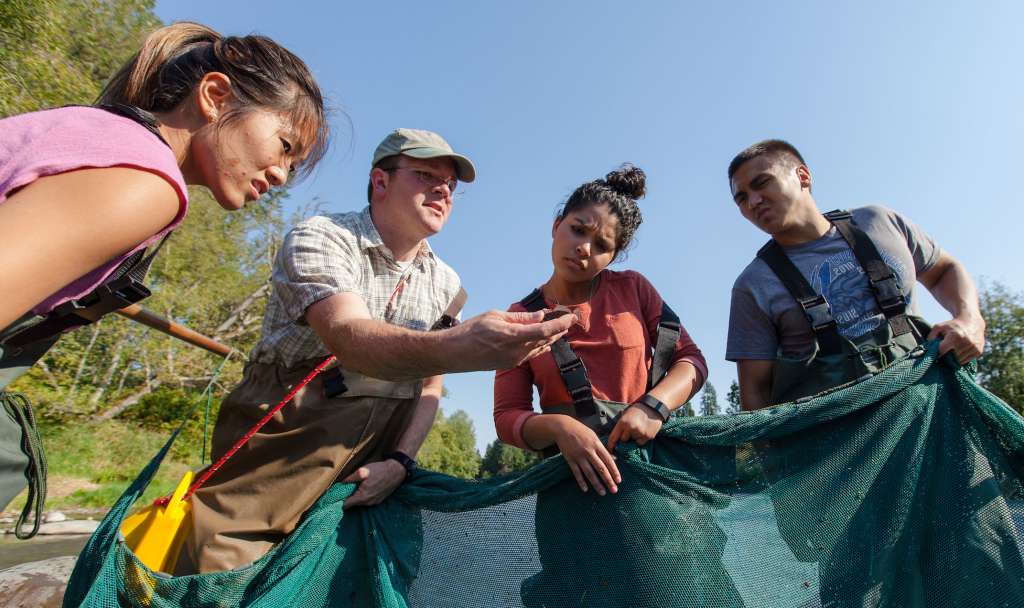 Professor Egge with students in river