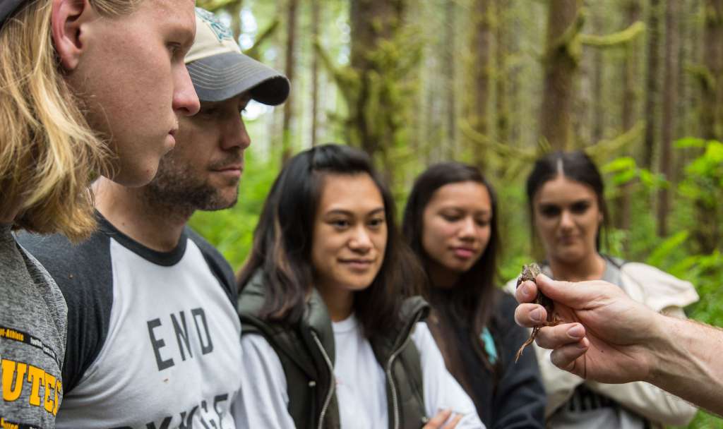 Jacob Egge with students in woods.