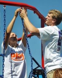 two students fixing swing