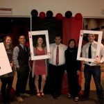 Students dressed nicely, posing with oversized playing card and dice props