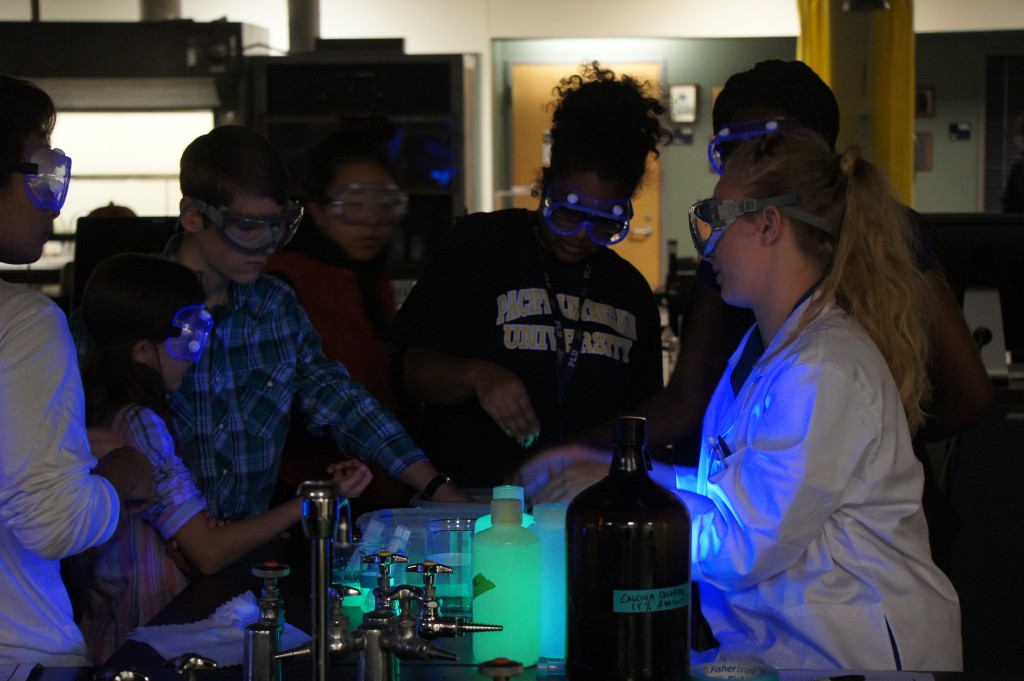 Students with googles on watching a demo in the dark