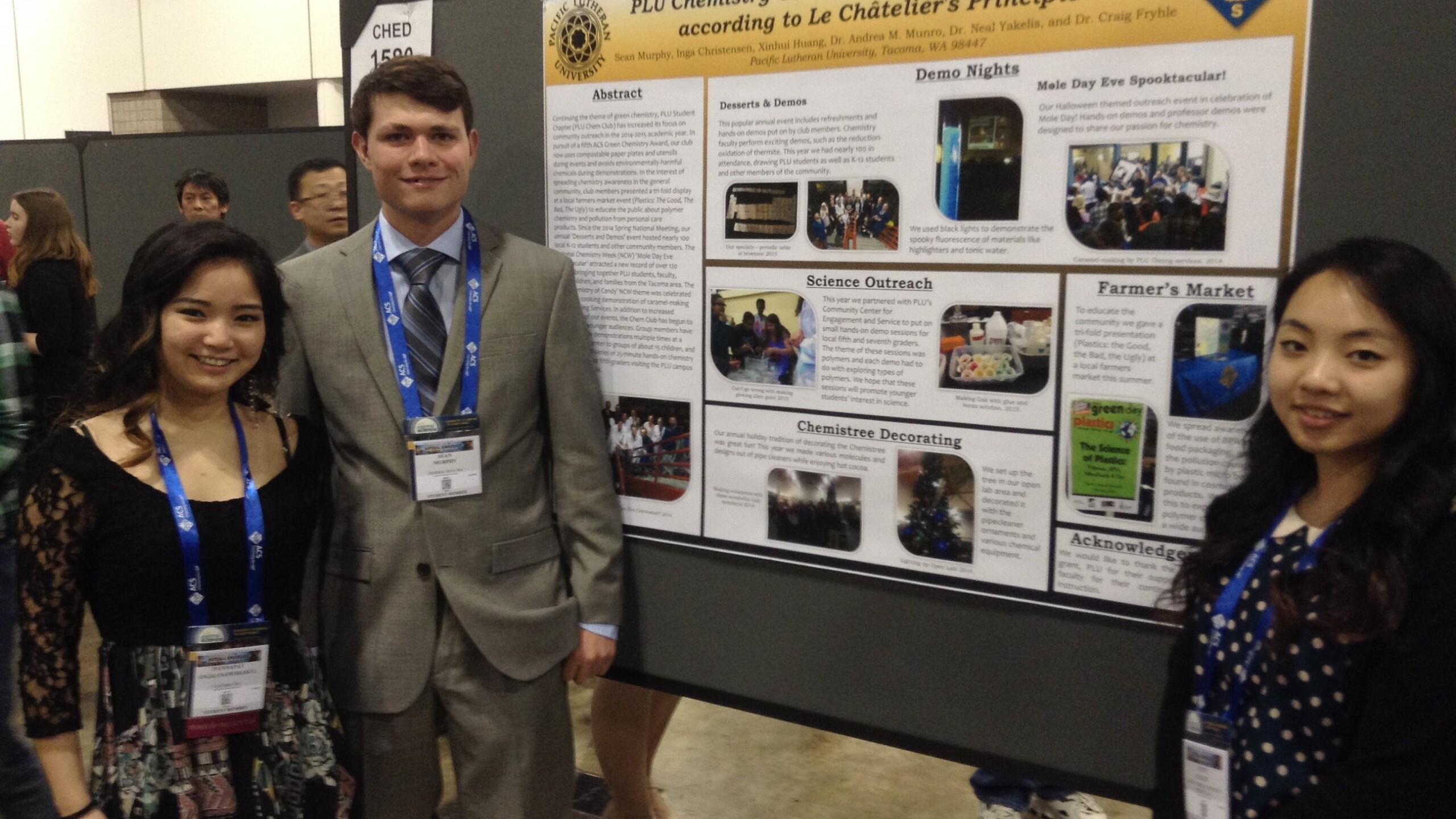 3 students standing next to their Chemistry Club display