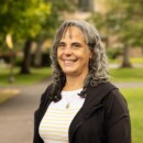Smiling woman with long gray hair in park pathway