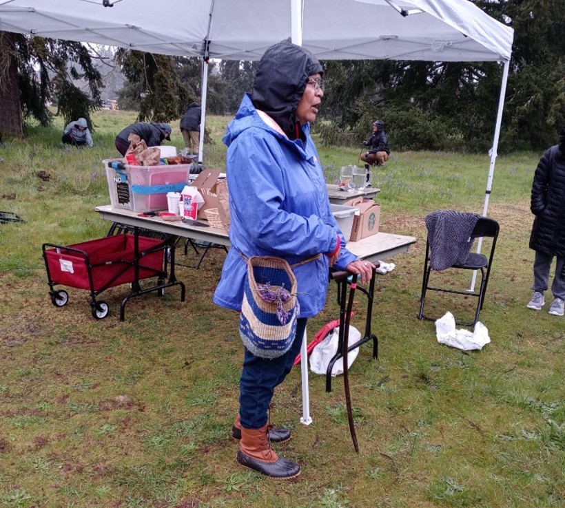 woman in rain gear getting ready to harvest camas