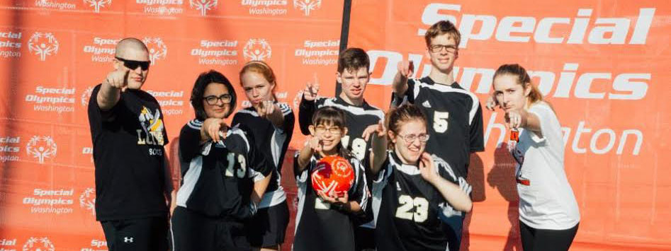 Group of students pointing at camera for Special Olympics
