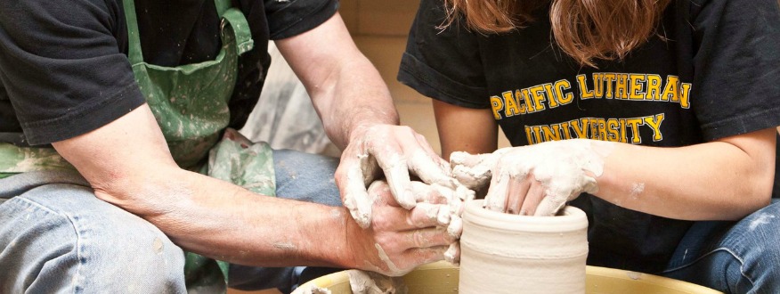 Two students working on pottery wheel