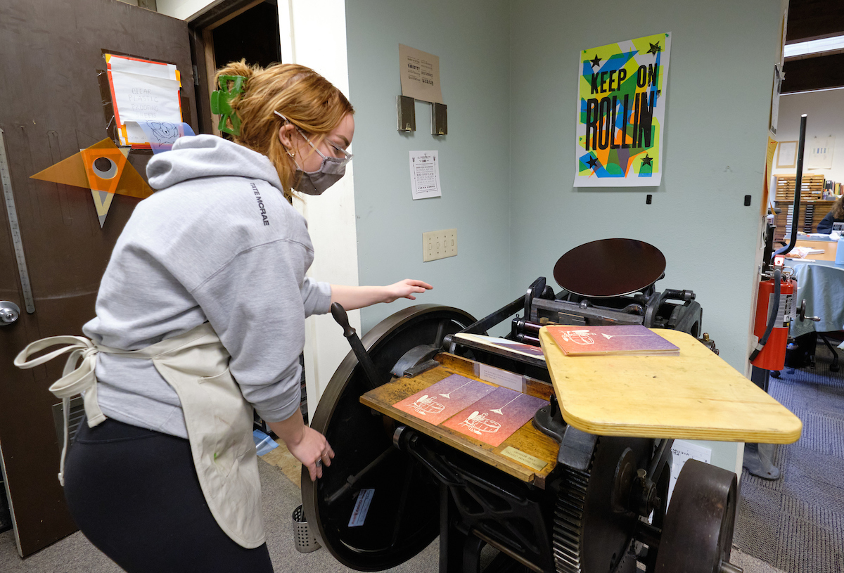 Student operating a printing press