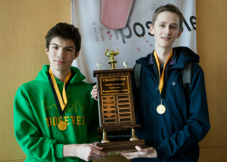 Two students holding a big trophy