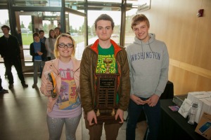 3 students holding trophy