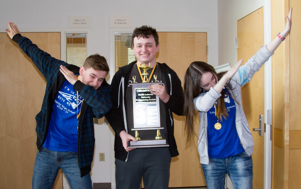 3 students holding trophy