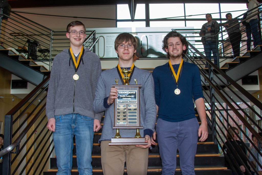 3 students holding trophy