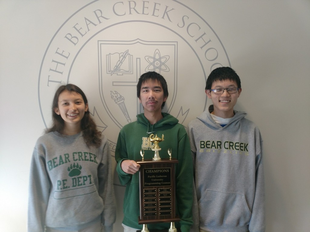 3 students holding trophy