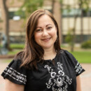 photo of a woman in an embroidered shirt standing in Red Square at PLU