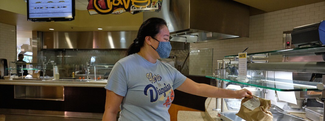 Student picking up food at the Commons