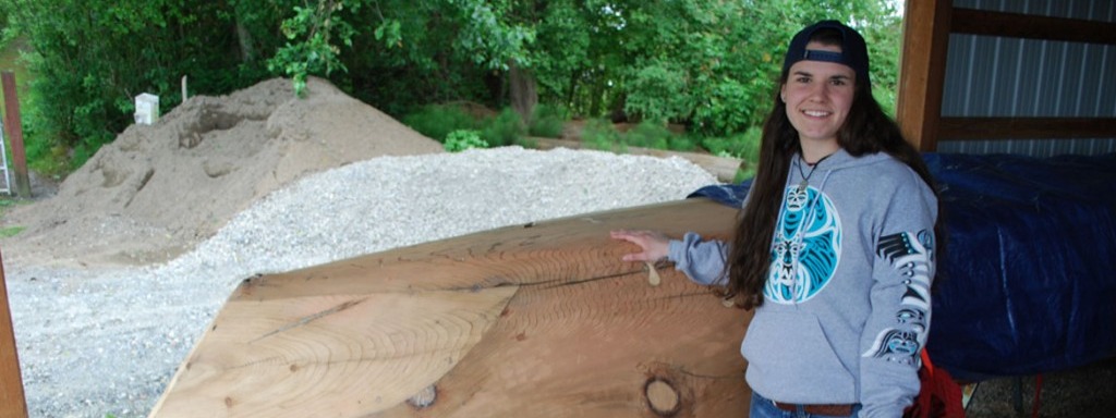 Kelly Hall standing next to a canoe.