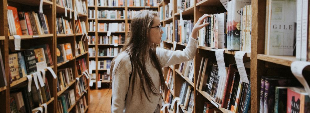 image-2018-11-20-4 Student looking at books on shelves