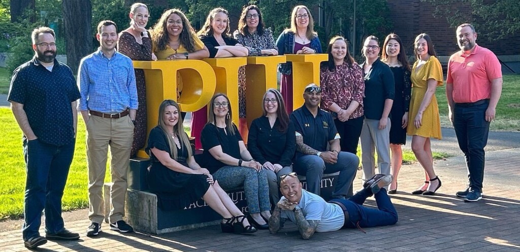 A group of principals standing around the block letters PLU