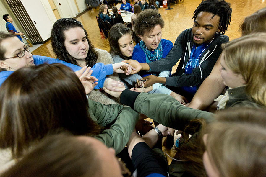 Explore students gathered in a circle holding hands