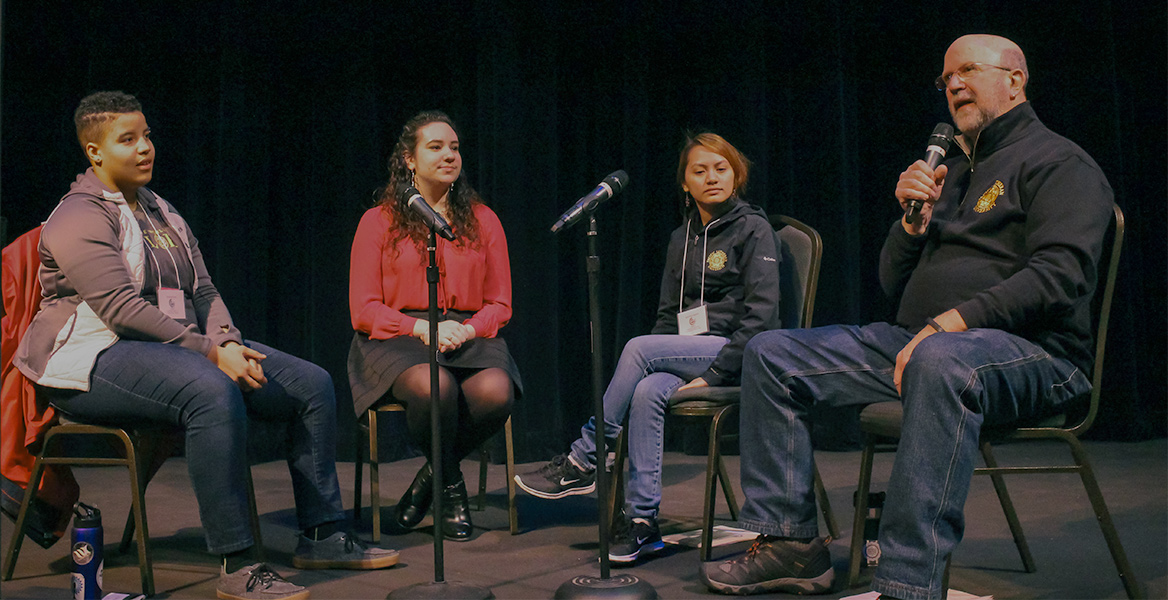 Campus Minister talking on stage with some students