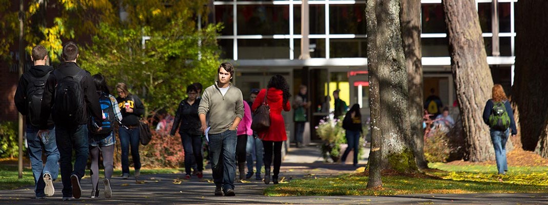 PLU students walking in front of the Hauge Administration building.