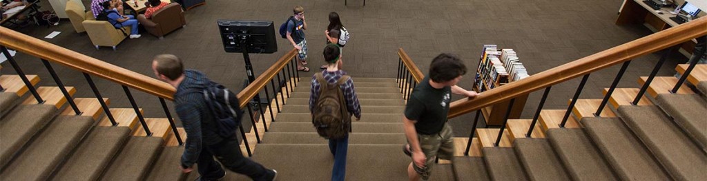 Students walking around in the Mortvedt Library lobby.