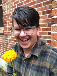 A photo of Dylan Ruggeri with a yellow flower