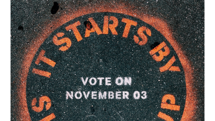 It starts by showing up: vote on November 3rd written in spray paint on a road.
