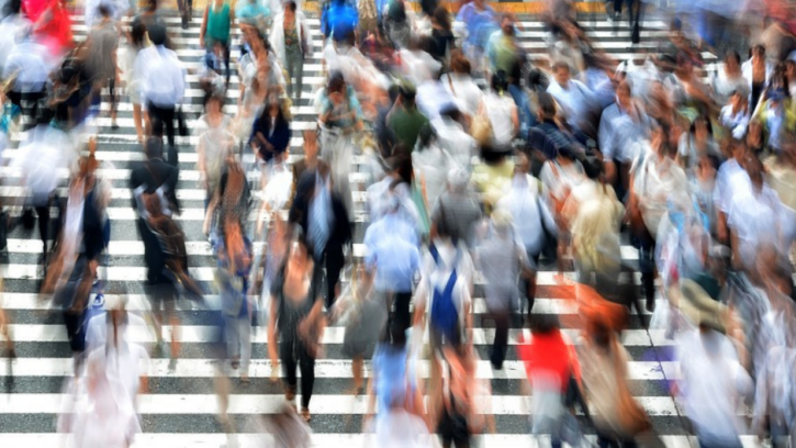 Blurred picture of people walking on a crosswalk.