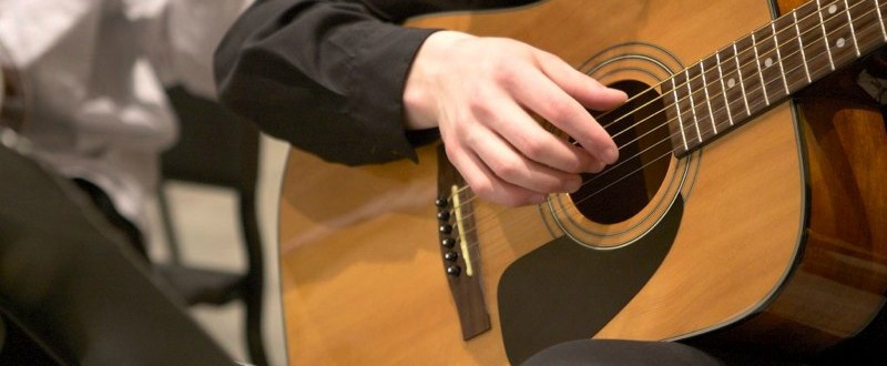 Student struming on guitar