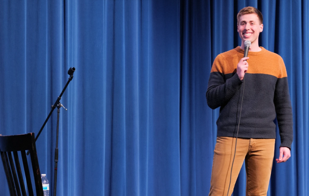 Image of Sam Ellefson on stage for comedy show