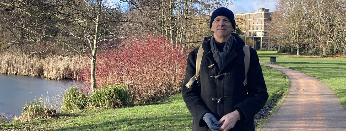 Arthur Strum outside on a trail by a lake.