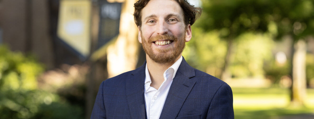 Professional man in navy blazer smiling outdoors