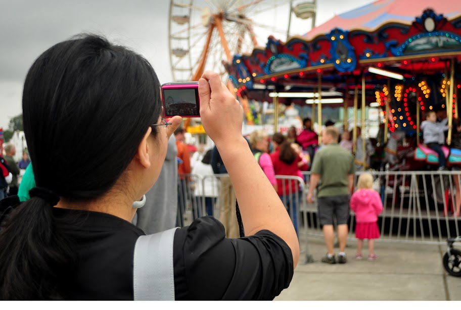 student taking a photo of a carousel