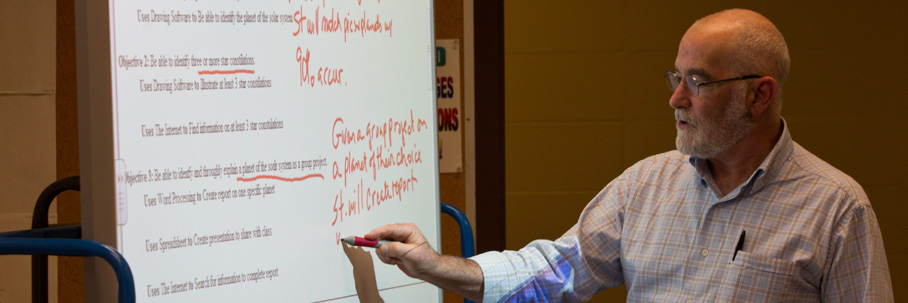 Professor Lenny Reisberg writing on smart board