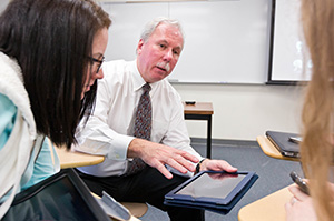 Gary Mahon showing ways of using tablets and phone apps for nursing to students Julia Carvalho '16, Kerri Selk '16, and Crescent Clover '16 at PLU on Wednesday, Feb. 25, 2015. (Photo/John Froschauer)