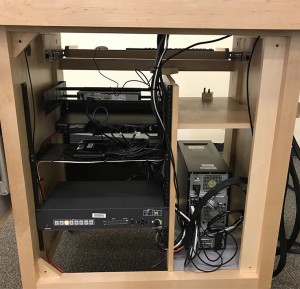 A podium without the back panel before the update; wires are tied off neatly.
