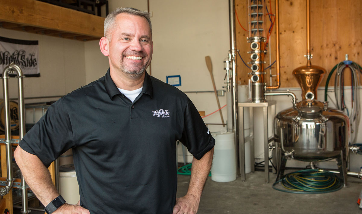 Raymond Bunk, MBA alumnus, smiles inside of his Nightside Distellery