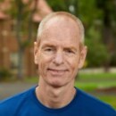photo of Ron Byrnes standing in front of a building and trees