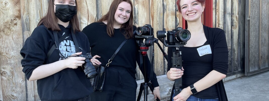 Three students holding cameras.