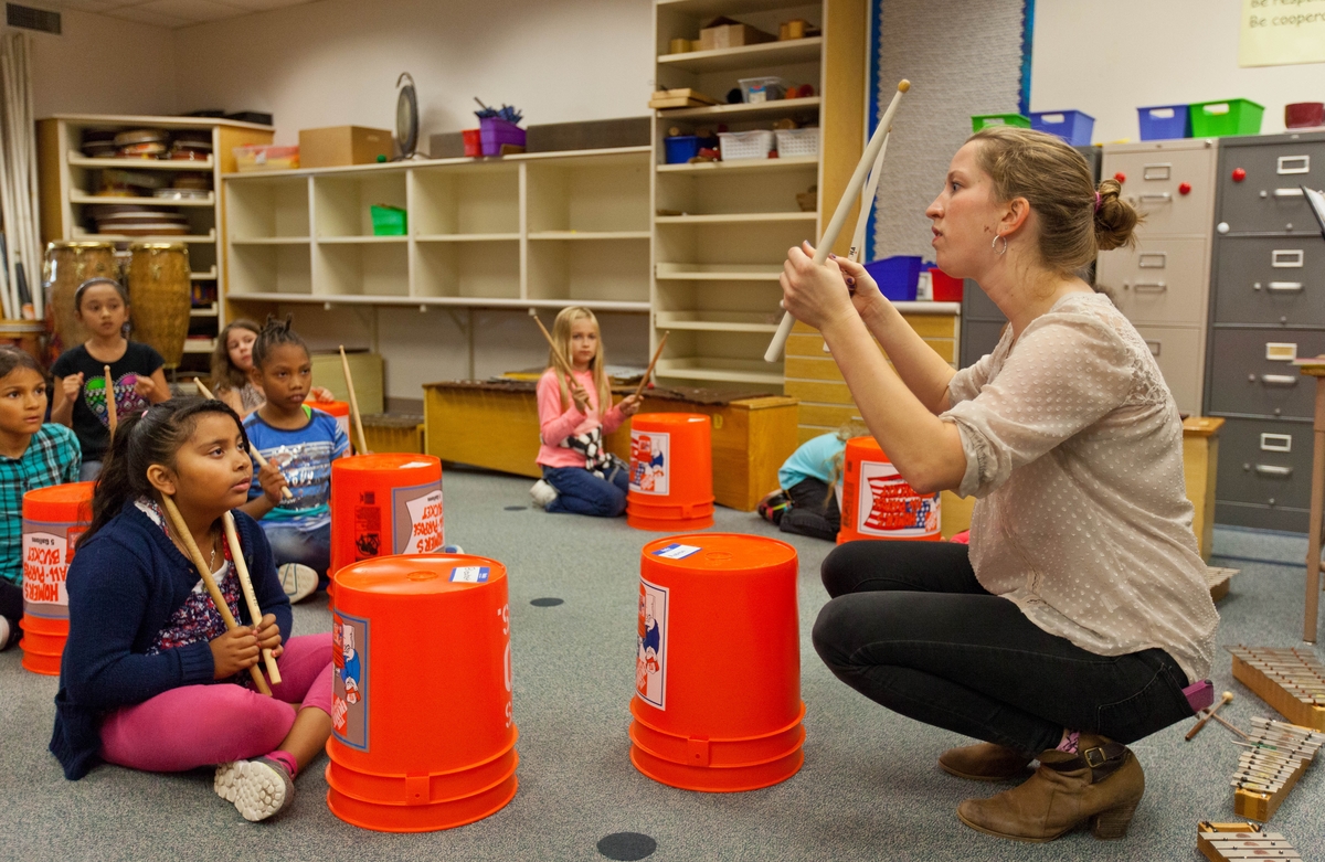 Student teaching the drums to young people