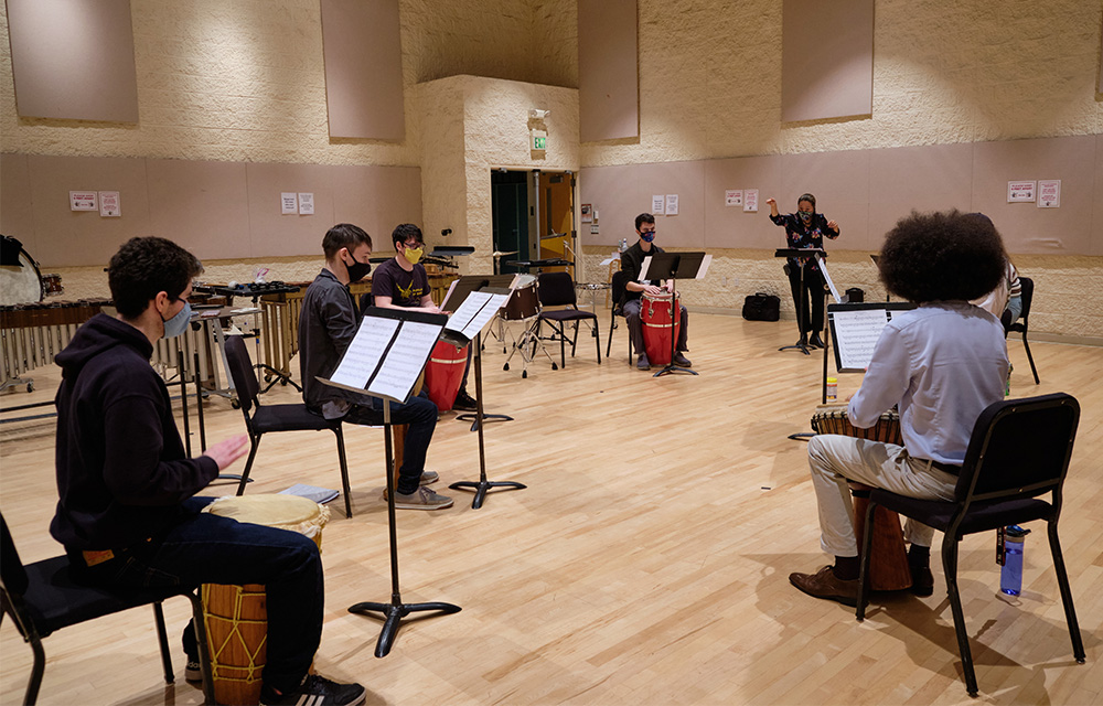 Dr. Miho Takekawa conducts a socially distant Percussion Ensemble class, rehearsing Dr. Greg Youtz’s composition entitled “Calypso Variations” in a large rehearsal space in the music building.