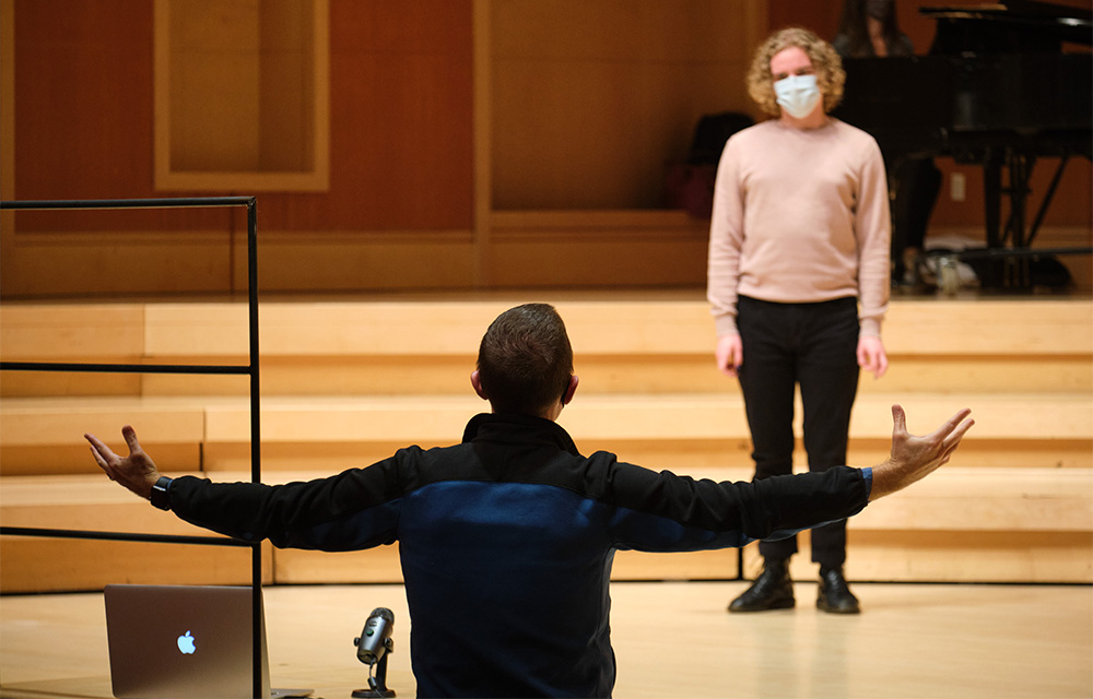 Dr. James Brown gestures widely at vocal student Jackson Wray in a socially distant vocal seminar.