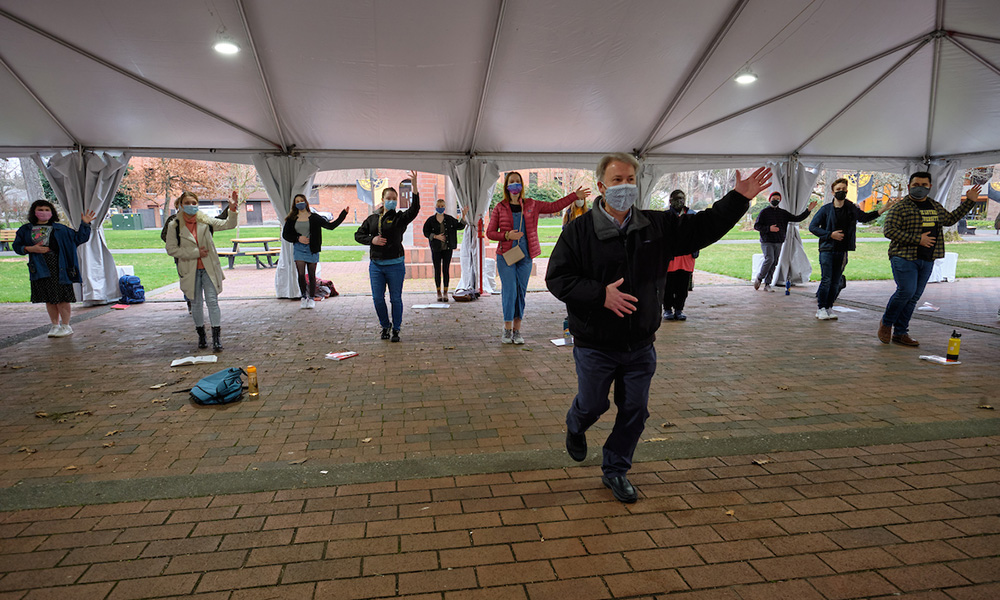 Dr. Barry Johnson leads a movement rehearsal under the ent in Red Square.