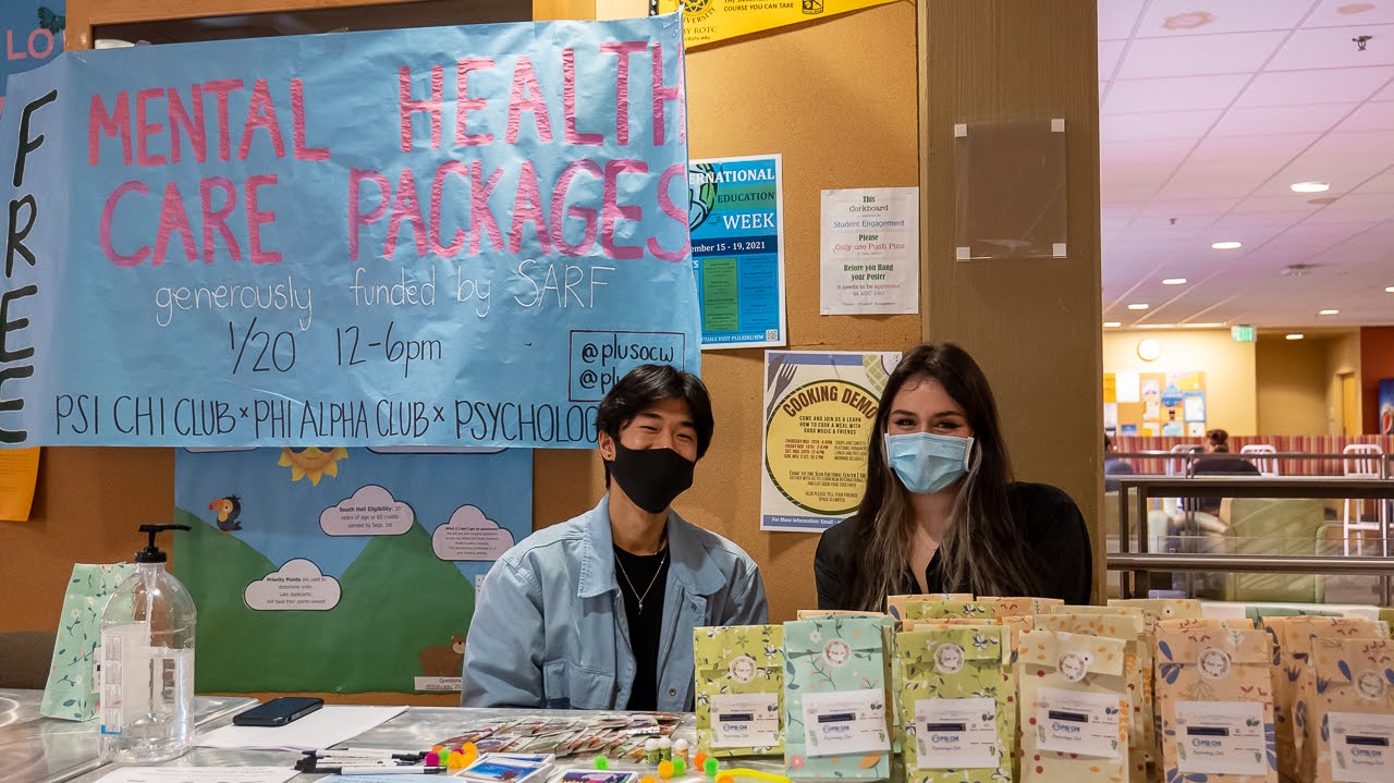 two students volunteering at an info table