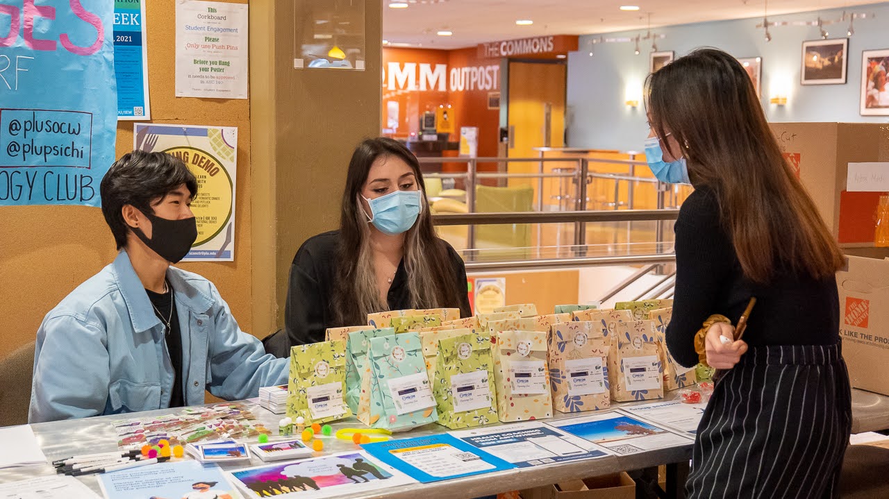 students volunteering at an info table